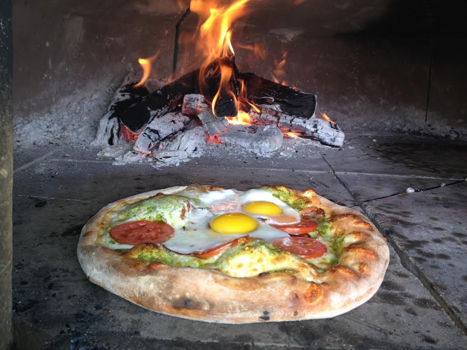 Specialty egg overeasy pizza